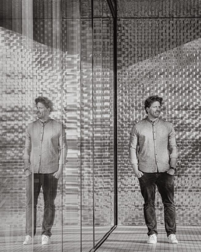 Architektenportrait vor einem Gebäude in Heilbronn. dass durch seine einzigartige Bauweise es möglich macht das Portrait mehrfach zu spiegeln.