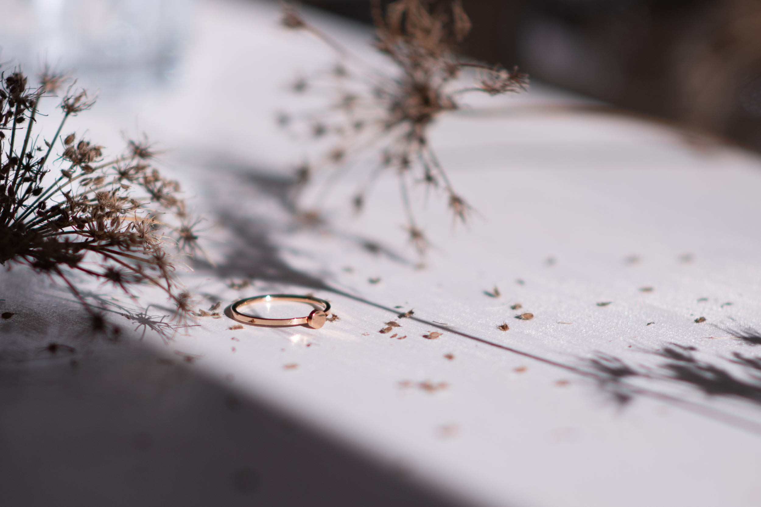 Schmuckcafe - Handmade Jewerly Designering in Licht und Schatten auf einem Tisch liegend